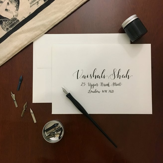 Black calligraphy writing on a white envelope with calligraphy pen | Kelly Chandler Consulting