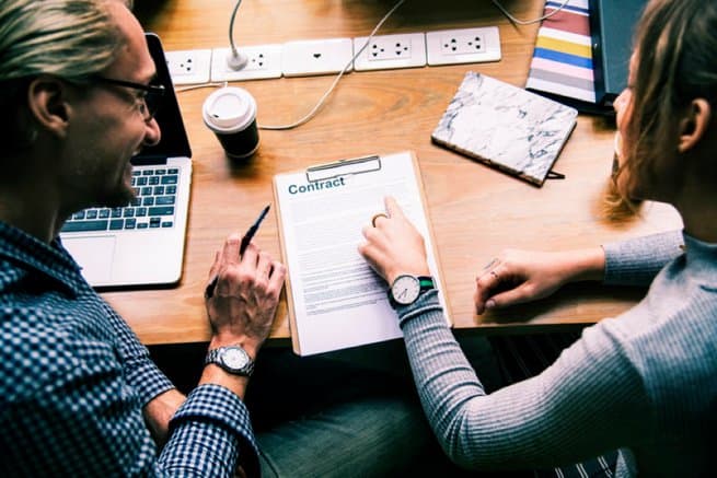 Man and woman signing a contract | Kelly Chandler Consulting