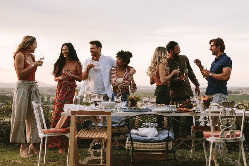 Young people having an outdoor pre wedding dinner party weekend wedding add on