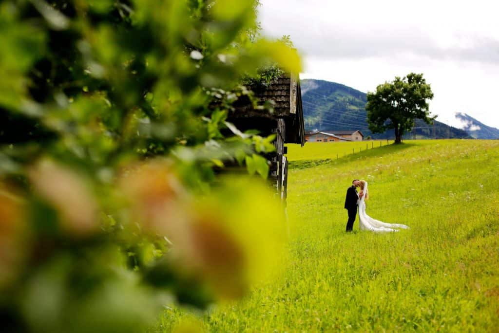 Bridal couple kissing in a green field