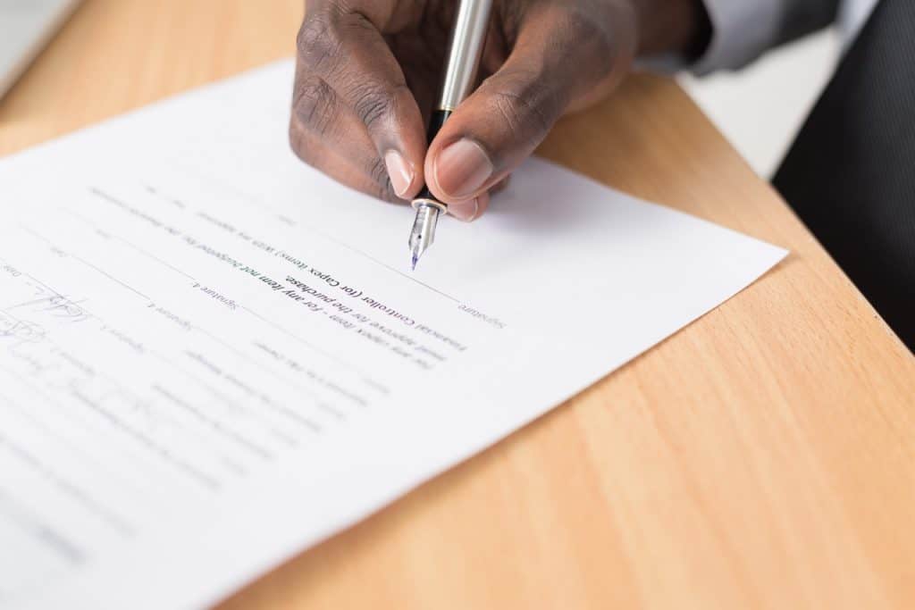 Close up of a mans hand signing a contract