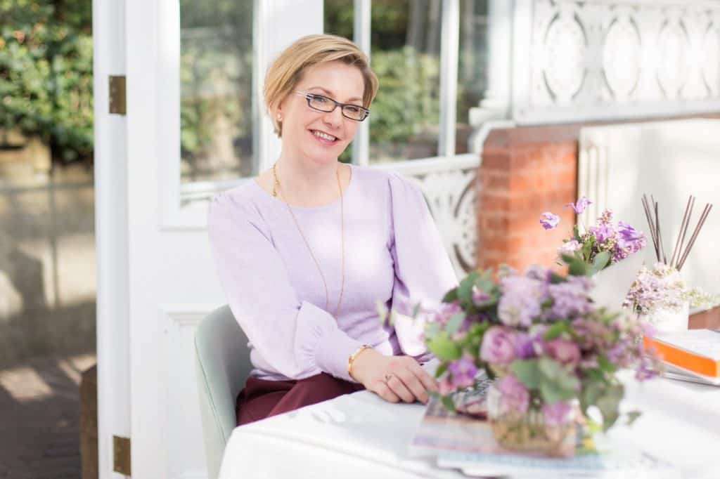 Woman sitting at a table smiling with lap top