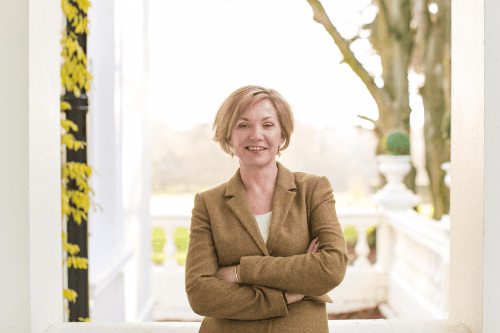Woman wearing tweed jacket with arm folded Kelly Chandler Consulting